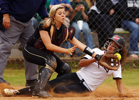 Mid-Carolina High School's Carli Ruff slides safe into home plate past Pendleton High School catcher Ansley Garrison in the seventh inning of the first game of their double-header in Pendleton on Wedn
